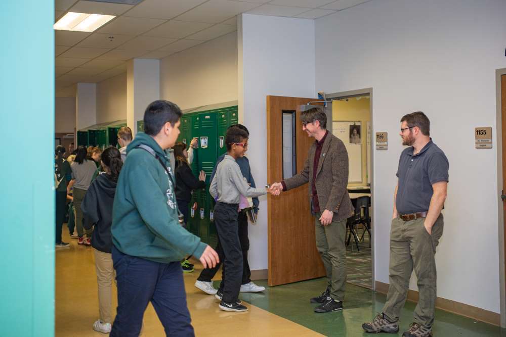 student shaking hands with his teacher in the hallway of Twin Peaks Classical Academy PK-12 tuition-free charter school