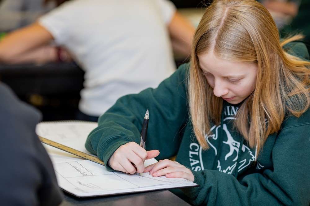 win Peaks Classical Academy tuition-free charter school student working with a ruler and notebook at her desk