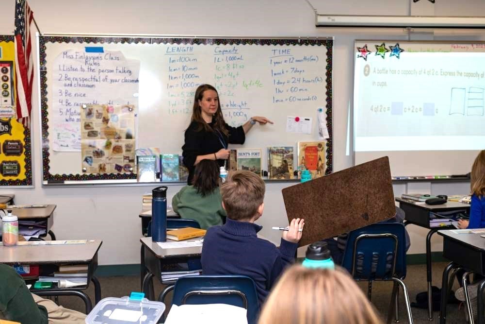Twin Peaks Classical Academy tuition-free charter school teacher pointing to white board while students listen at their desks